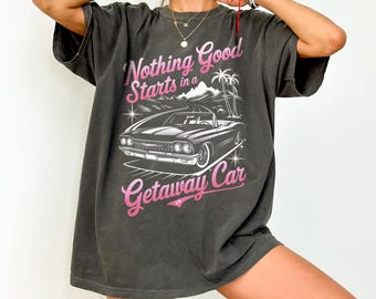 May include: A dark gray t-shirt with a graphic print of a vintage car and the text "Nothing Good Starts in a Getaway Car".