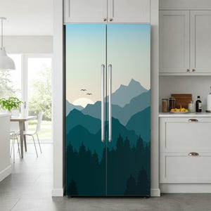 Può includere: Rivestimento per frigorifero con un design a paesaggio montano. L'opera raffigura strati di montagne blu e verde acqua, un sole al tramonto e alberi a silhouette. Il rivestimento copre le ante del frigorifero, creando un elettrodomestico da cucina artistico.
