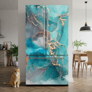 a large refrigerator with a marble-like design in shades of blue and gold, situated in a kitchen with a wooden floor and a cat sitting on the floor in front of it.