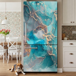 a refrigerator with a vibrant turquoise and gold marble-like design, creating a striking and modern aesthetic. A dog is sitting on the floor in front of the refrigerator, adding a cozy and homely touch to the scene.