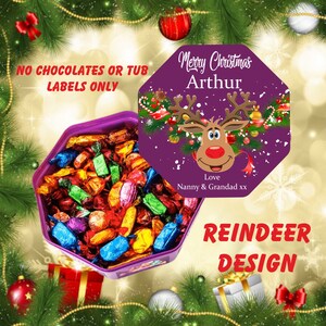 Peut inclure: Bo&icirc;te octogonale violette remplie de chocolats assortis. Le couvercle de la bo&icirc;te pr&eacute;sente un motif de renne violet avec le texte "Merry Christmas Arthur Love Nanny & Grandad xx". Le texte "NO CHOCOLATES OR TUB LABELS ONLY" est visible sur la bo&icirc;te.