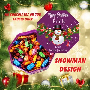 Peut inclure: Bo&icirc;te octogonale violette remplie de chocolats assortis. Le couvercle de la bo&icirc;te pr&eacute;sente un motif de bonhomme de neige avec le texte "Merry Christmas Emily" et "Love Auntie Jackie xx". Le texte "NO CHOCOLATES OR TUB LABELS ONLY" est visible sur la bo&icirc;te.