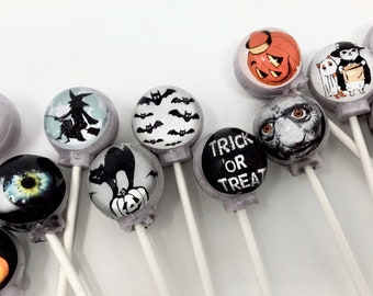 May include: A collection of Halloween-themed lollipops with various designs, including a witch, bats, a black cat, a pumpkin, a ghost, and the words "Trick or Treat".