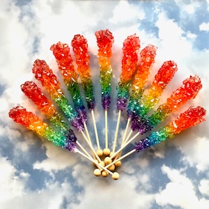 May include: A rainbow rock candy bouquet with 12 individual candy sticks on wooden sticks. The candy is arranged in a fan shape with the sticks meeting at the bottom.