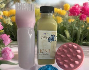May include: A collection of hair care products, including a pink applicator bottle, a bottle of "HONII Detangling Moisture Mask", a blue collapsible funnel, and a pink scalp massager. The products are set against a backdrop of colorful flowers.