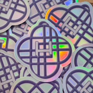 Puede incluir: Una colección de pegatinas holográficas con un diseño geométrico. Cada pegatina presenta una forma de trébol de cuatro hojas con un patrón de cuadrícula y la letra "H" en el centro. Las pegatinas tienen un acabado brillante e iridiscente.