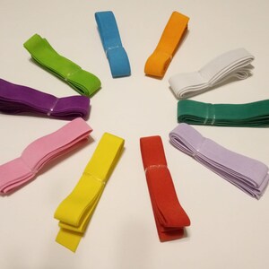 May include: Assortment of 10 colors of elastic fabric, including purple, pink, yellow, red, green, white, light blue, orange, and two shades of green. The elastic is folded and arranged in a circle on a white surface.