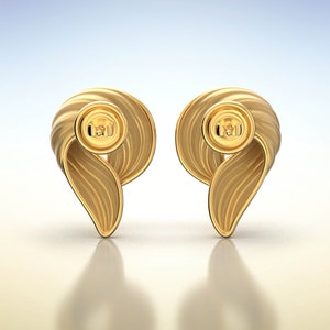 Puede incluir: Un par de pendientes de oro con un dise&ntilde;o retorcido en forma de onda. Los pendientes tienen un peque&ntilde;o bot&oacute;n redondo de oro en el centro.