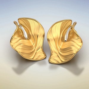Puede incluir: Un par de pendientes de oro con un dise&ntilde;o ondulado y org&aacute;nico. Los pendientes est&aacute;n hechos de dos piezas de metal que se unen en el medio. El metal es de color dorado brillante y tiene un acabado liso.