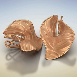 Puede incluir: Un par de pendientes de oro rosa con un dise&ntilde;o ondulado y org&aacute;nico. Los pendientes est&aacute;n hechos de metal y tienen un acabado pulido.