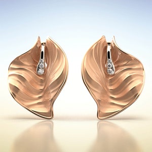Puede incluir: Un par de pendientes de oro rosa con un dise&ntilde;o de hoja y un peque&ntilde;o acento de diamante.