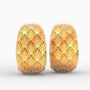 Puede incluir: Dos pendientes dorados de estilo Art D&eacute;co. Cada pendiente tiene forma ovalada con un patr&oacute;n detallado en forma de abanico. Los pendientes est&aacute;n sobre un fondo blanco, resaltando su intrincado dise&ntilde;o y brillo met&aacute;lico.