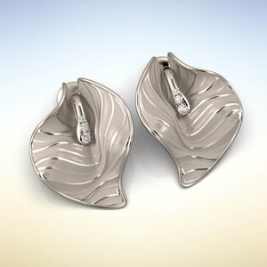 Puede incluir: Un par de pendientes de plata con forma de hojas, superficie texturizada y peque&ntilde;as piedras preciosas transparentes.