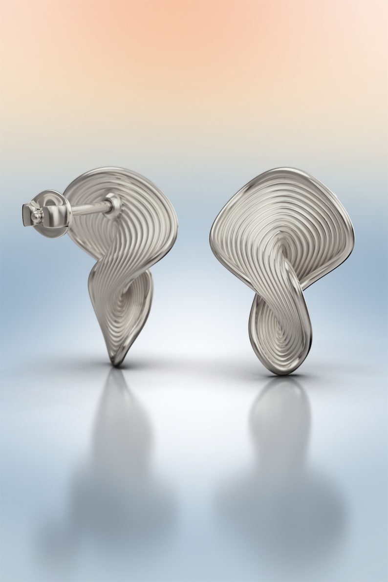 May include: A pair of silver earrings with a unique, twisted, and textured design. The earrings have a post back closure.