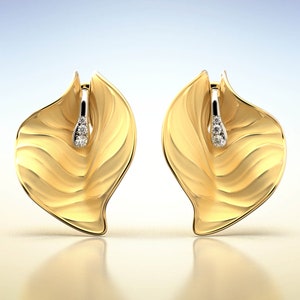 Puede incluir: Un par de pendientes de oro en forma de hoja con un peque&ntilde;o acento de diamante en cada pendiente.