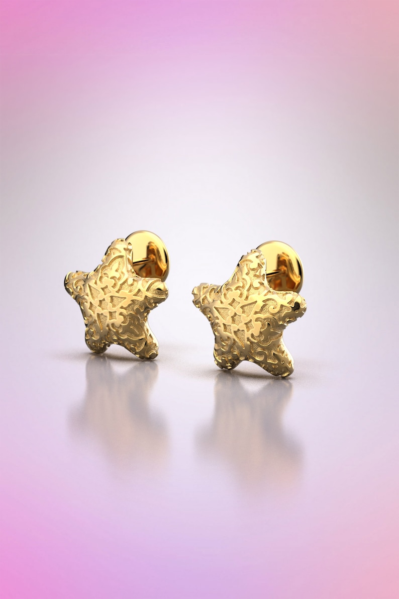 May include: A pair of gold star-shaped earrings with a textured surface.