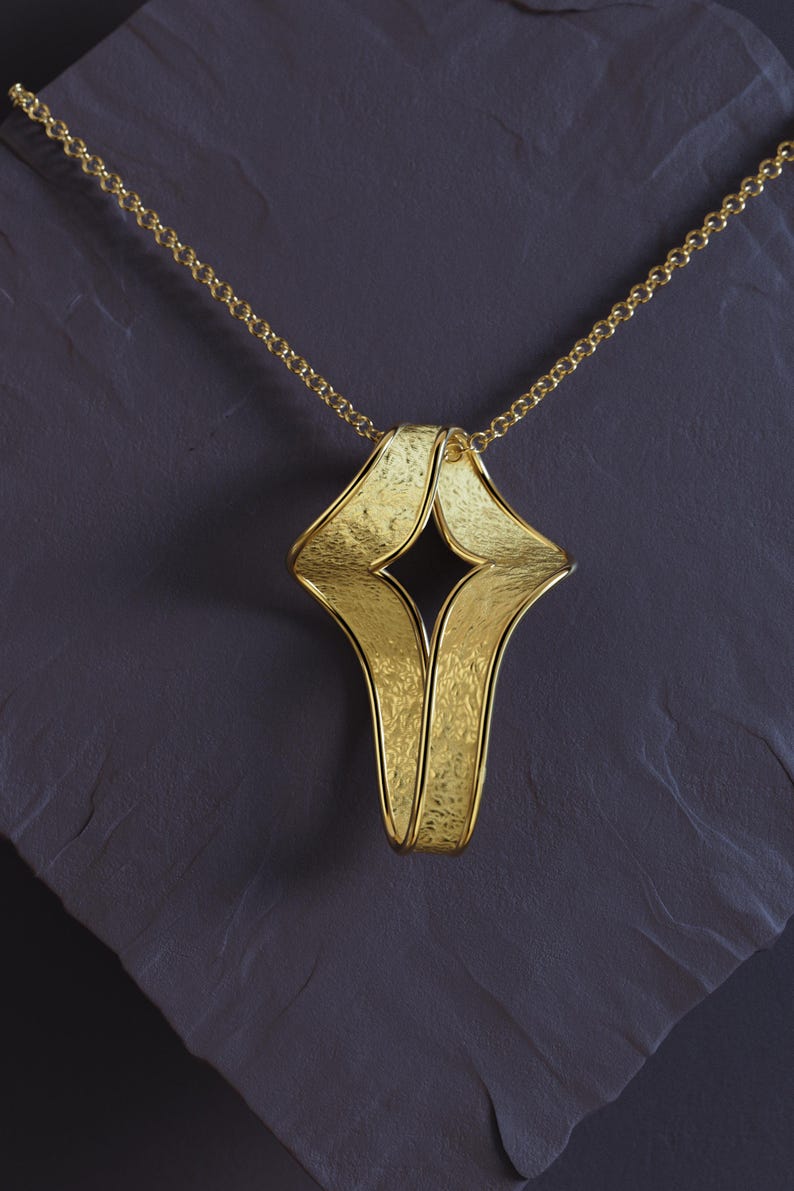 Solid gold twisted cross pendant with sandblasted texture and polished edges