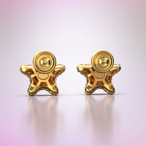 May include: A pair of gold star-shaped earrings with a textured surface. The earrings have a post back closure.