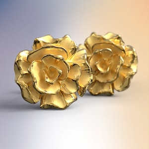 Puede incluir: Un par de pendientes de color dorado en forma de rosa. Los pendientes están hechos de un metal brillante y tienen un diseño de rosa realista.