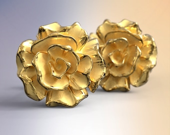 May include: A pair of gold-colored rose-shaped earrings. The earrings are made of a shiny metal and have a realistic rose design.