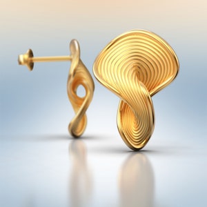 May include: A pair of gold-toned earrings with a unique, twisted, and textured design. The earrings have a post and back closure.