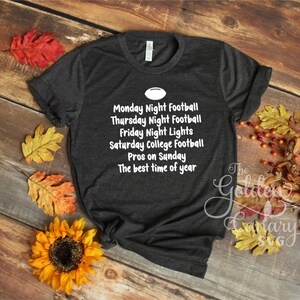 Peut inclure: Un t-shirt gris fonc&eacute; avec du texte blanc qui dit "Monday Night Football, Thursday Night Football, Friday Night Lights, Saturday College Football, Pros on Sunday, The best time of year".