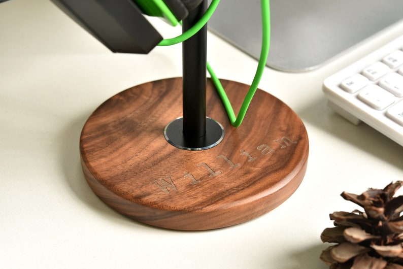 May include: A wooden headphone stand with a black metal pole and a circular base. The base is engraved with the name "William".