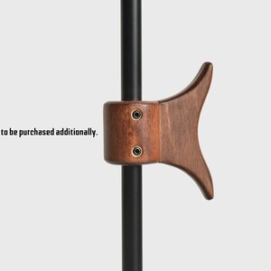 May include: A wooden hook with a dark brown finish, attached to a black metal rod. The hook is shaped like a fish tail and has two small screws visible on the side.