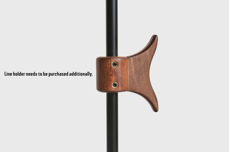 May include: A wooden hook with a dark brown finish, attached to a black metal rod. The hook is shaped like a fish tail and has two small screws visible on the side.