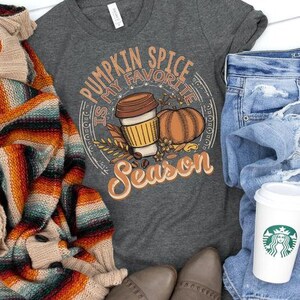 May include: A dark gray t-shirt with the text "Pumpkin Spice is my favorite season" in a white circle with a brown coffee cup and a pumpkin illustration.