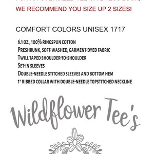 K&ouml;nnte beinhalten: Eine wei&szlig;e Textgrafik auf schwarzem Hintergrund mit dem Text "Wildflower Tee's" in einer kursivschriftlichen Schriftart. Der Text ist mittig auf dem Bild platziert. Unter dem Text befindet sich ein kleines graues Blumenmuster.