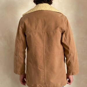May include: A brown corduroy jacket with a sherpa collar. The jacket has a button closure and long sleeves.