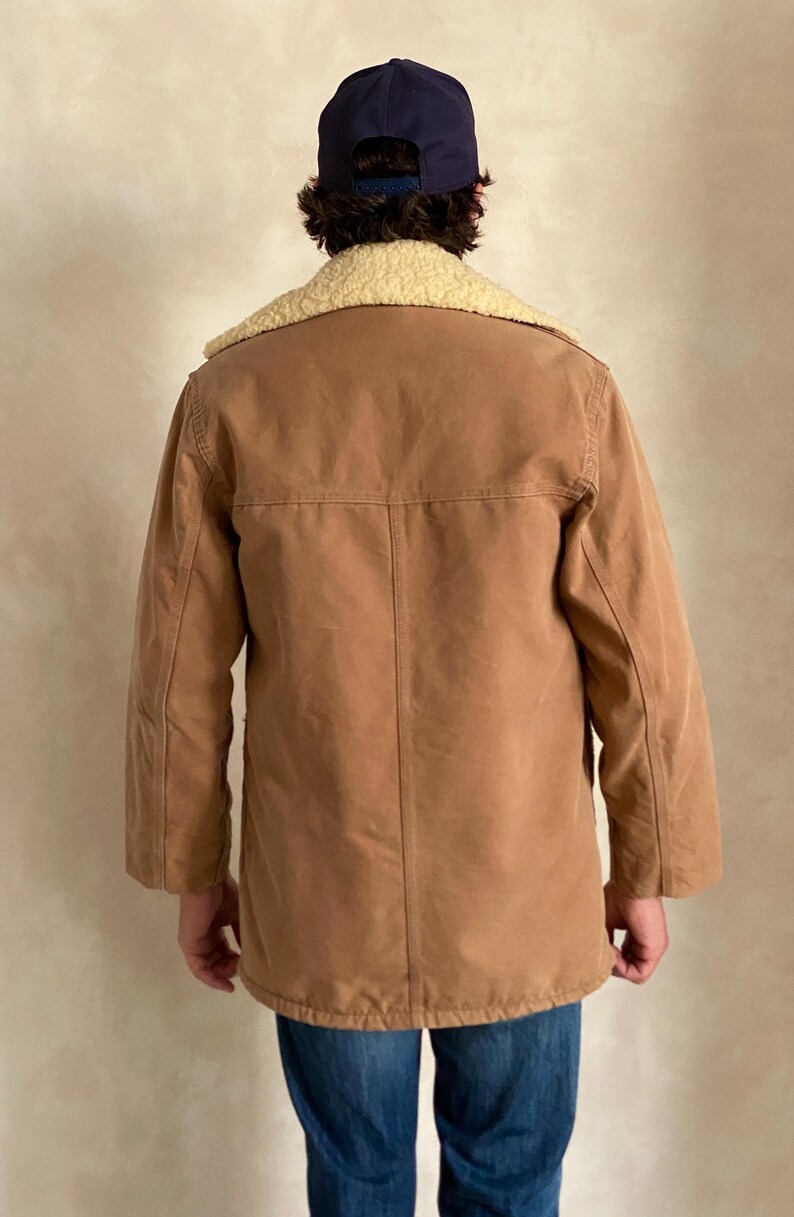 May include: A brown corduroy jacket with a sherpa collar. The jacket has a button closure and long sleeves.