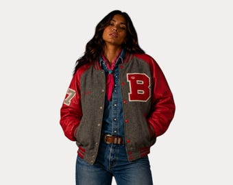 Op de afbeelding: Een grijze en rode varsity jas met de letter "B" en het nummer "7". De jas heeft rode leren mouwen en een grijze wollen body. De jas is dichtgeknoopt en heeft een geribbelde kraag en manchetten.