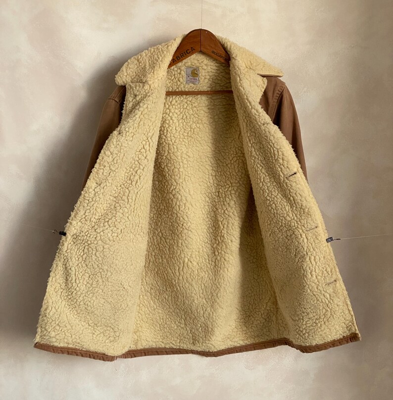 May include: A brown corduroy jacket with a sherpa lining. The jacket has a button closure and two pockets on the front.
