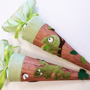 Könnte beinhalten: Zwei grüne und braune Stoffkegel mit einem Chamäleon- und einem Eidechsen-Design. Die Kegel sind mit grünen Blättern und einem grün-weiß karierten Stoff verziert.