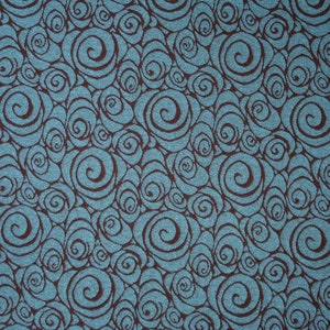 May include: A teal blue fabric with a repeating pattern of brown swirls.