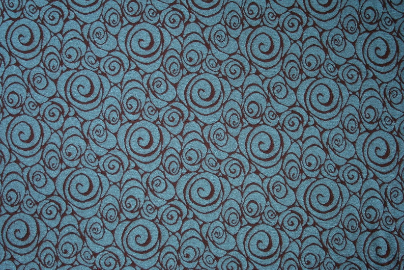 May include: A teal blue fabric with a repeating pattern of brown swirls.