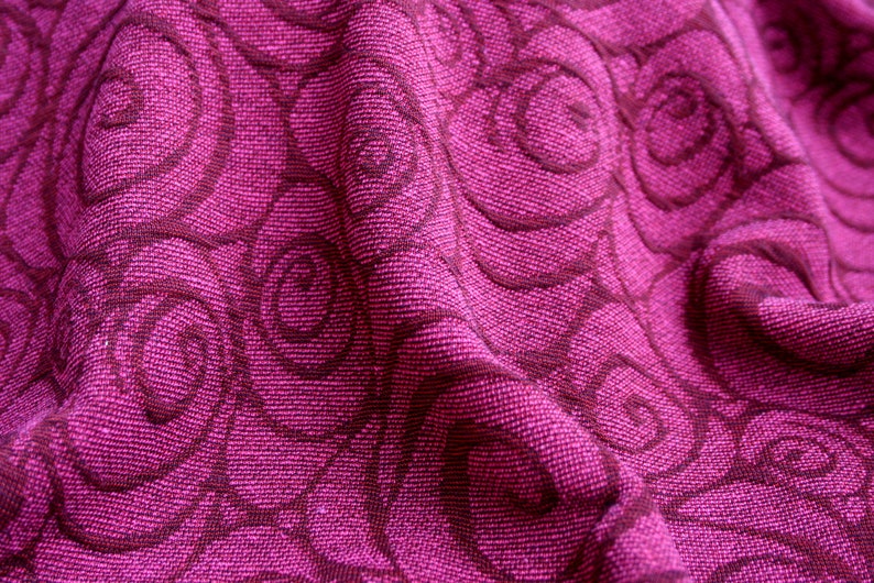 Peut inclure: Gros plan sur un tissu textur&eacute; magenta vif. Le tissu pr&eacute;sente un motif r&eacute;p&eacute;titif de motifs tourbillonnants en forme de rose dans une nuance plus fonc&eacute;e de magenta, cr&eacute;ant un contraste et une profondeur subtils.