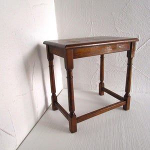 Könnte beinhalten: Kleiner, antiker Holztisch mit rechteckiger Platte und vier gedrehten Beinen. Der Tisch ist aus dunkelbraunem Holz gefertigt und hat ein klassisches Design. Der Tisch ist ca. 61 cm lang, 41 cm breit und 51 cm hoch.