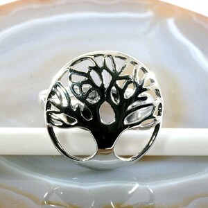 Könnte beinhalten: Ein silberner Ring mit einem Lebensbaum-Design. Der Ring ist aus Metall und hat eine runde Form.