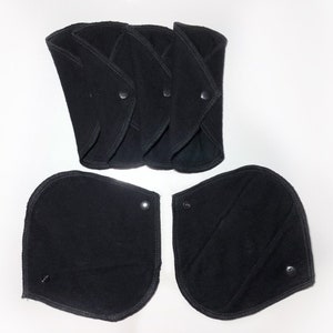 May include: Five black reusable cloth menstrual pads with snaps. Two additional pads are shown separately.