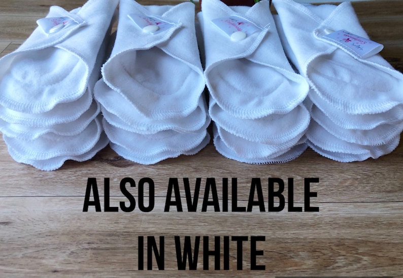 May include: A stack of white reusable cloth pads, folded and ready to use.  The text "ALSO AVAILABLE IN WHITE" is printed below the pads.