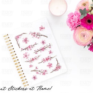 May include: A sheet of stickers with watercolor illustrations of pink cherry blossoms on branches. The stickers are on a white background and are arranged in a variety of sizes and positions. The text "Instant Stickers at Home!" is written in black at the bottom of the sheet.