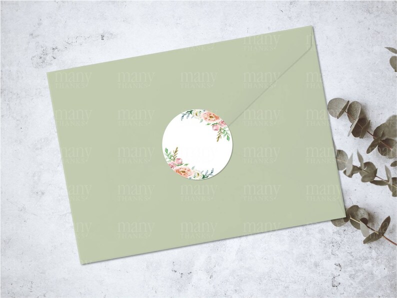 May include: A round sticker with a watercolor floral design in shades of pink, white, and green. The sticker is on a light green envelope.