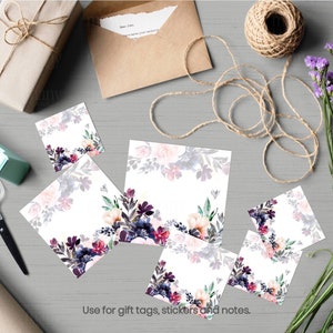 May include: Five square gift tags with a watercolor floral design in shades of pink, purple, and green. The tags are on a gray surface with a brown envelope, twine, and a roll of tape.