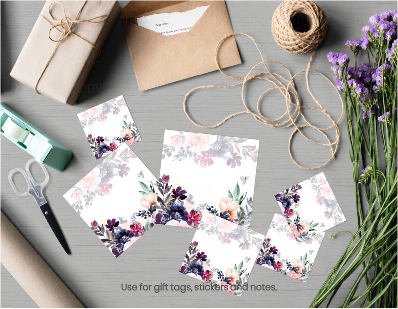 May include: Five square gift tags with a watercolor floral design in shades of pink, purple, and green. The tags are on a gray surface with a brown envelope, twine, and a roll of tape.