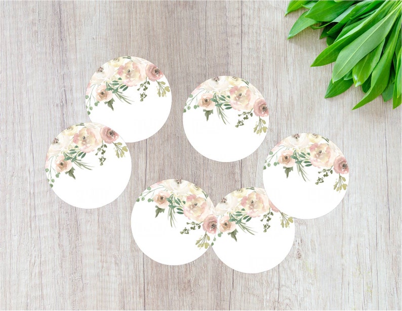 May include: Six round white paper labels featuring a watercolour floral design in shades of pink and green. The flowers are clustered at the top of each label.