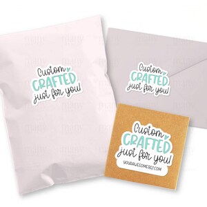 K&ouml;nnte beinhalten: Drei Aufkleber mit dem Text "Custom Crafted just for you!" in hellblauer Schrift mit einem kleinen Herzsymbol. Die Aufkleber befinden sich auf einem wei&szlig;en Umschlag, einem braunen Umschlag und einem wei&szlig;en Versandbeutel.