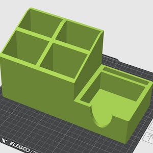 Könnte beinhalten: Ein 3D-gedruckter, limettengrüner Schreibtisch-Organizer. Er hat vier quadratische Fächer oben und einen unteren Bereich mit einem gebogenen Ausschnitt. Der Organizer steht auf einer schwarzen Gitteroberfläche, ideal für Büro oder Zuhause.